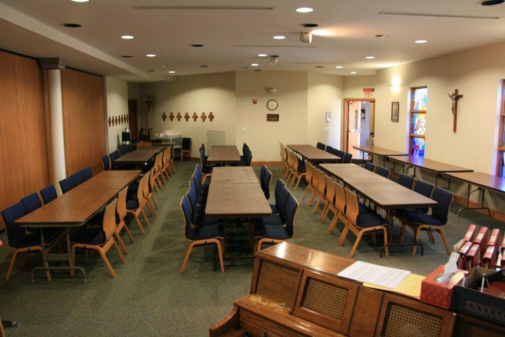 Gaspar Meeting Room with long wooden tables and blue chairs.